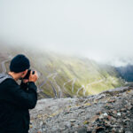 Hiking Tourist Taking Photos Using His Hi-End Smartphone Device. Travel Concept. Mountain Hiker.